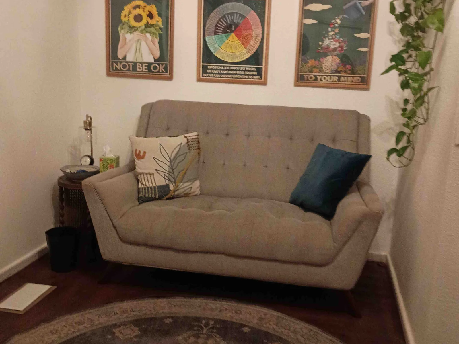 Clean and orderly therapy room with a couch, rug, and wall art in a Reno office.